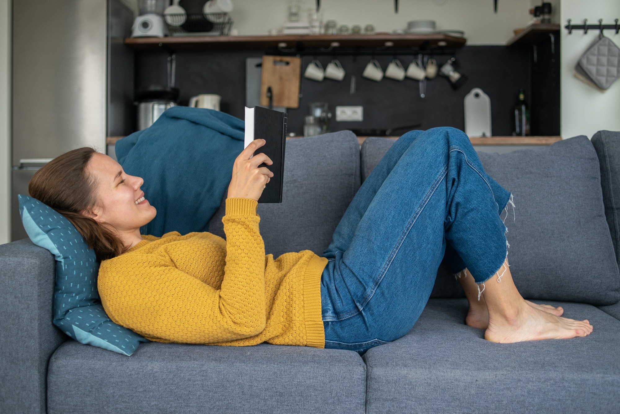 Woman reading book on couch